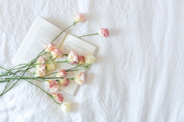 Flowers and a book on white linens | Photo by Matthew Henry