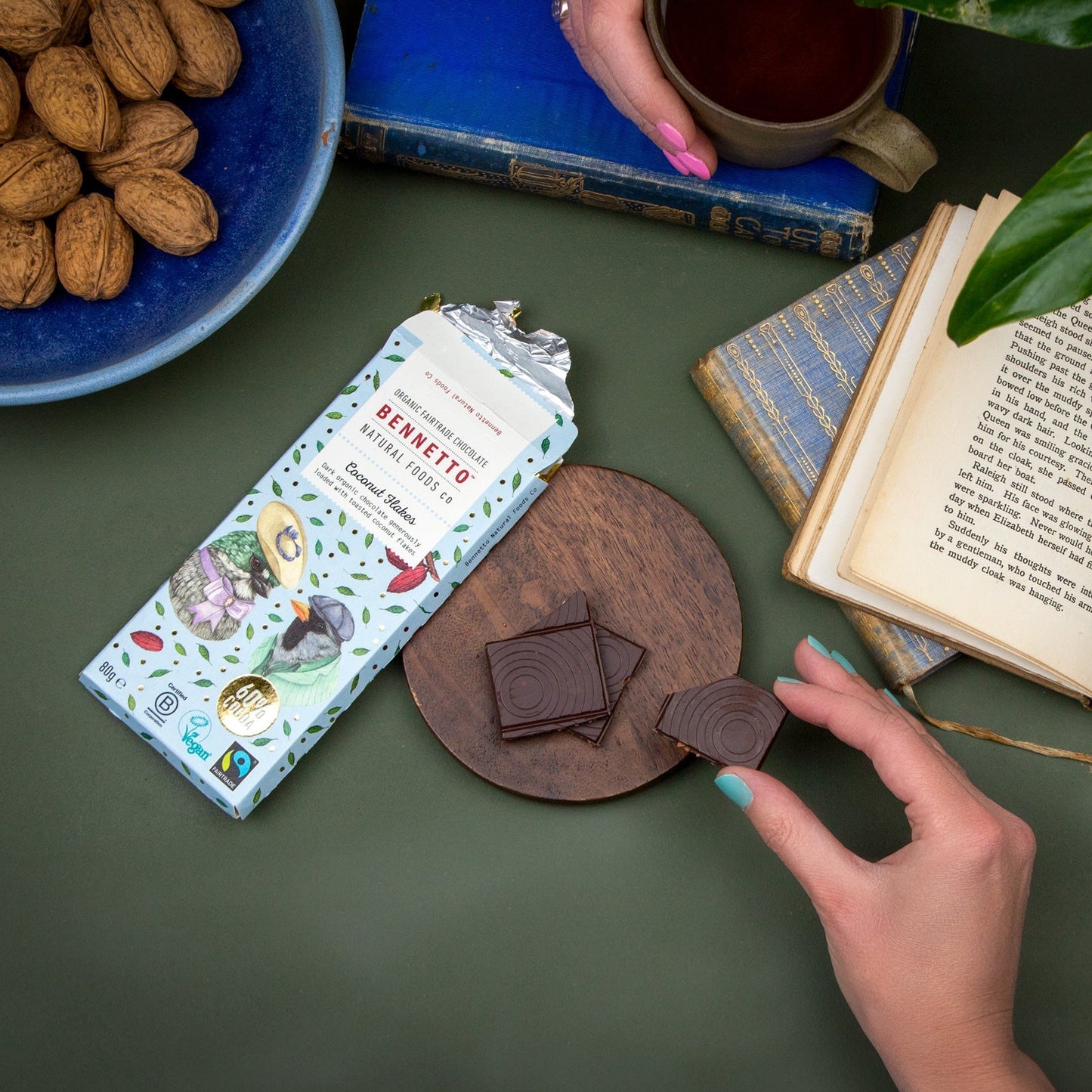 Sharing Bennetto Chocolate bar over a drink at a table with books and walnuts