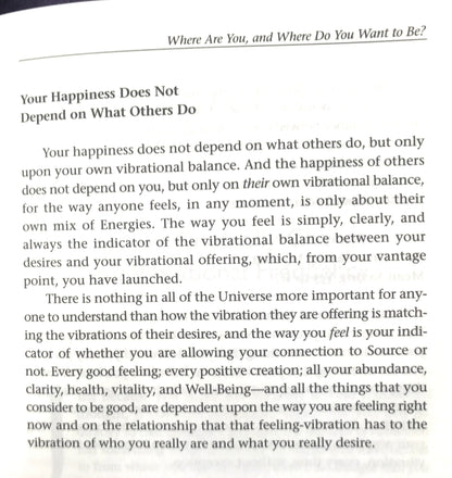 Text on a white background with motivational quote about happiness and personal vibration.
