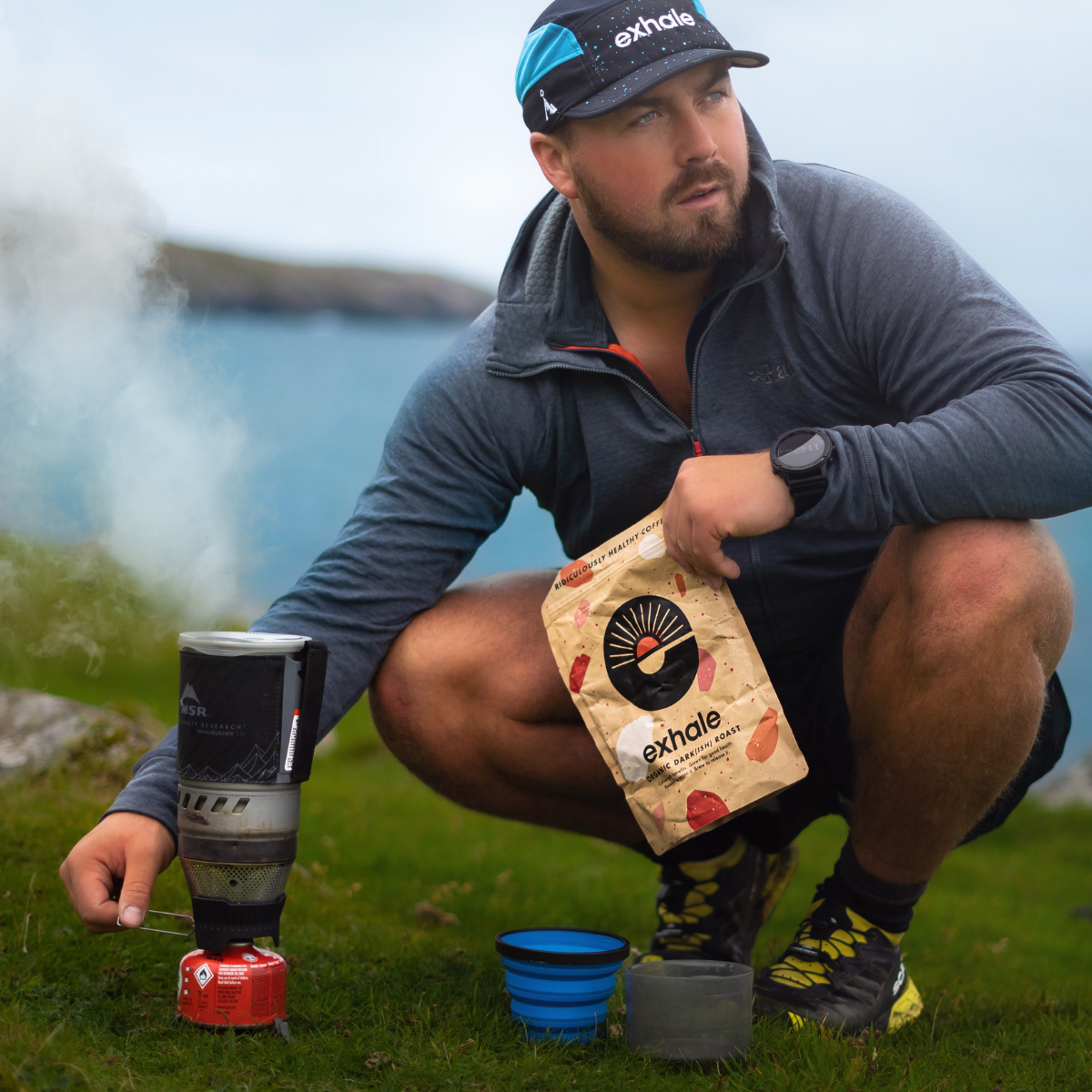 Man outdoors using a camping stove with Exhale products