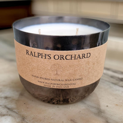 Candle with 'Ralph's Orchard' label on a marble surface