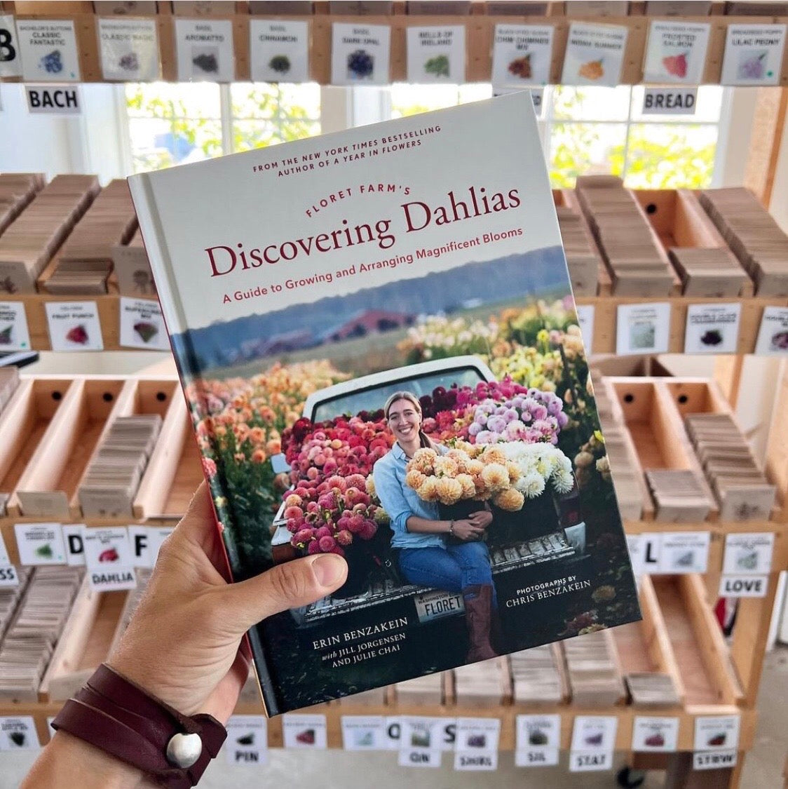 Floret’s Discovering Dahlias book, in front of Floret seed packs 