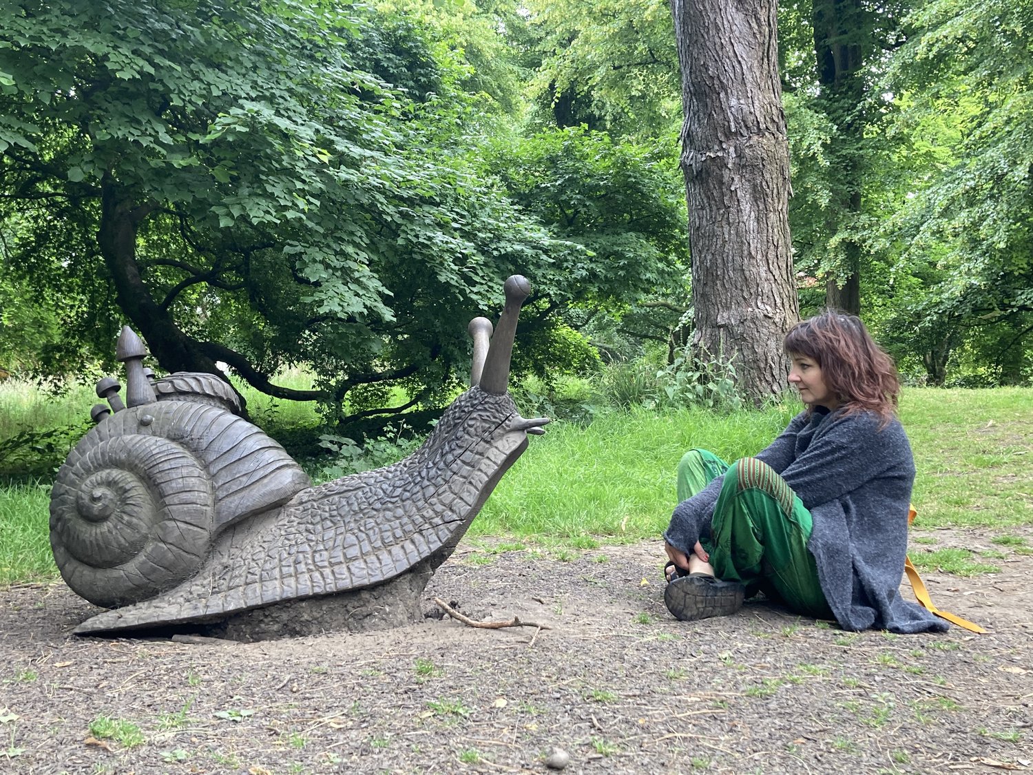 Illustrator [ Rebecca Harry - sitting in a forest looking at a large nail sculpture