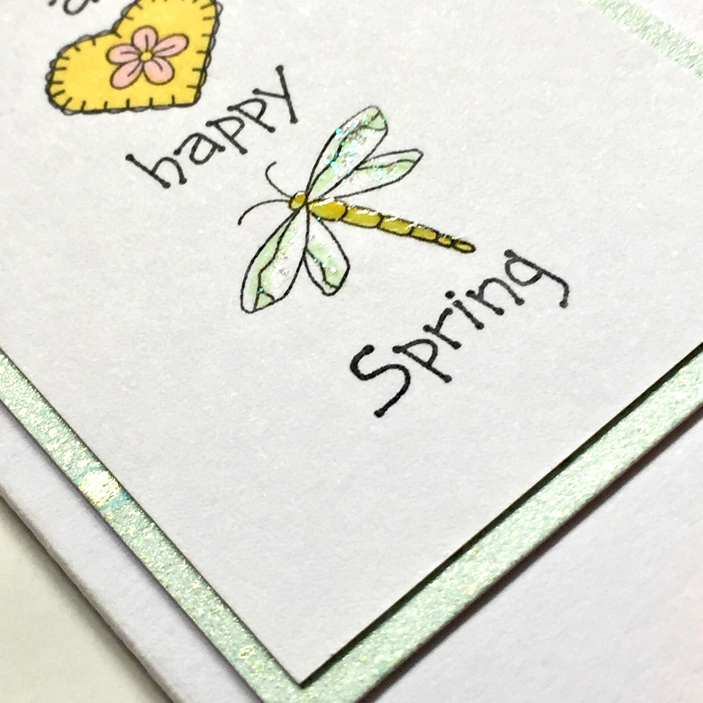 Layered card embellished card details of a stamped and coloured dragonfly 