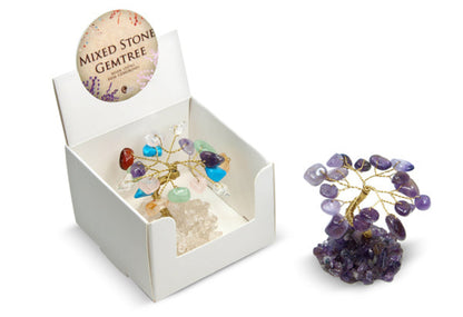 A mixed stone gemtree crystal tree figurine shown both inside its white display box and standing outside on a white background. The tree features a gold-colored metal wire structure adorned with various colored gemstone chips, mounted on a purple amethyst geode cluster base.